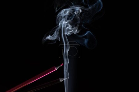 Téléchargez les photos : Crayons pointus roses et gris avec fumée sur fond noir - en image libre de droit