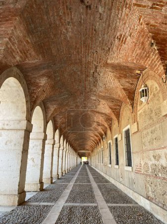Photo for A vertical shot of an alley with old brick walls and arches in daylight - Royalty Free Image
