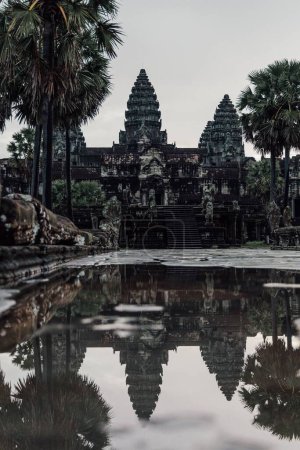 Photo for A vertical shot of  Angkor Wat Buddhist temple in Cambodia reflected on the water - Royalty Free Image