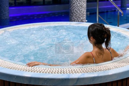 Foto de Un primer plano de una mujer tomando un baño de terapia en un jacuzzi en un traje de baño - Imagen libre de derechos