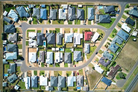 Téléchargez les photos : Une belle vue de drone de petites maisons et de routes dans une ville au lever du soleil - en image libre de droit