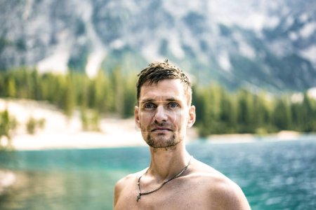 Téléchargez les photos : Un jeune homme torse nu regardant avec une vue visionnaire de la nature dans les montagnes des Dolomites - en image libre de droit