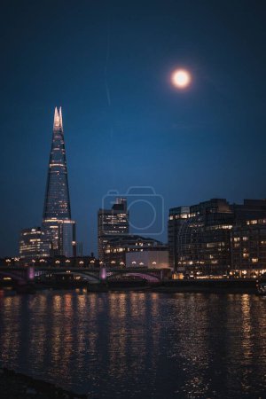 Foto de Un fondo de horizonte londinense con edificios iluminados y The Shard por la noche - Imagen libre de derechos
