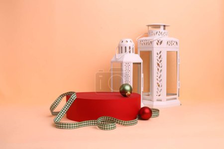 Foto de Una toma de estudio de una caja de regalo roja, cintas a cuadros, linternas y bulbos de árboles de Navidad - Imagen libre de derechos