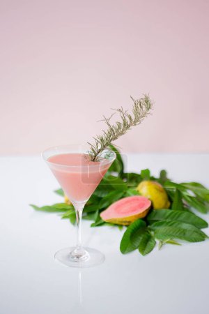 Téléchargez les photos : Un plan vertical du cocktail rose avec des fruits tropicaux et des feuilles en arrière-plan - en image libre de droit