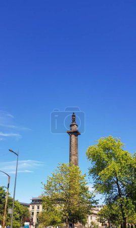Photo for A low-angle vertical shot of the historical Melville Monument surrounded by green trees under the blue sky - Royalty Free Image