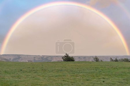 Foto de Un hermoso y espectacular arco iris completo en el verde campo de Medinaceli en un día de lluvias de primavera - Imagen libre de derechos