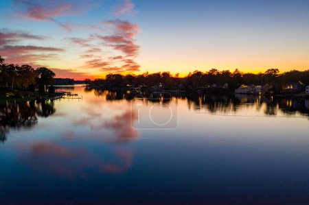 Téléchargez les photos : Une silhouette d'arbres au bord du lac au coucher du soleil - en image libre de droit