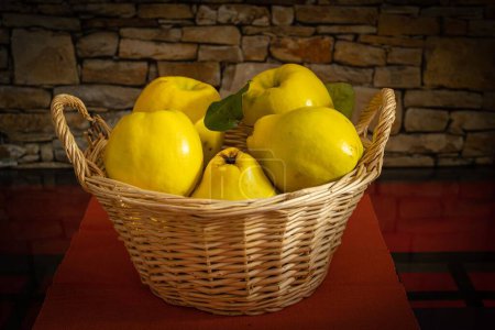 Photo for A closeup of a basket full of quinces against the brick wall - Royalty Free Image