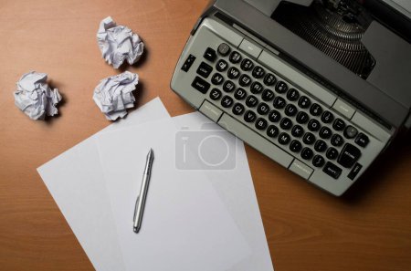Eine Großaufnahme einer Schreibmaschine mit leeren Papieren und einem Stift. Konzept der kreativen Krise.
