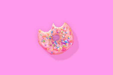Photo for A top view of a bitten donut with sprinkles isolated on a pink background - Royalty Free Image