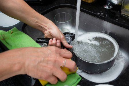 Téléchargez les photos : Un lave-vaisselle et des ustensiles féminins dans la cuisine - en image libre de droit