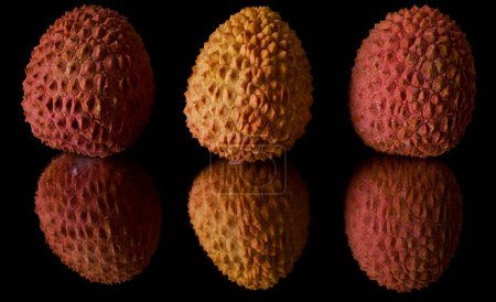 Photo for Close-up of three fresh lychees reflected in a mirror on a black background - Royalty Free Image