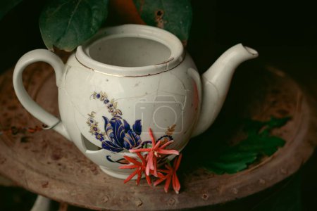 Photo for A closeup shot of a Broken porcelain tea kettle decorated with flowers - Royalty Free Image