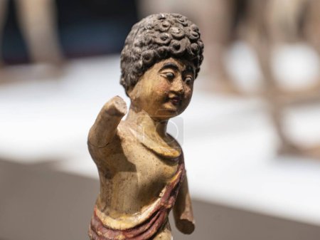 Téléchargez les photos : Un gros plan de la figurine en argile d'une femme est-asiatique aux cheveux bouclés et aux mains coupées sur un fond flou - en image libre de droit