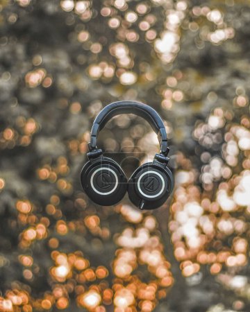 Photo for A vertical shot of a black Audio Technica headphone ATH M50x in the air - Royalty Free Image