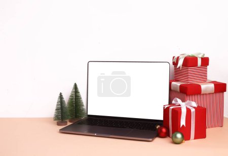 Photo for Cute Christmas setup with decorations and blank notebook screen in the middle for mockup - Royalty Free Image