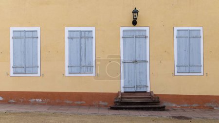 Téléchargez les photos : Un mur orange avec fenêtres et porte - en image libre de droit
