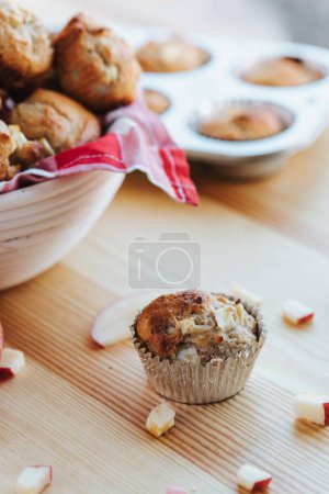 Téléchargez les photos : Un plan vertical des muffins dans un bol blanc et une forme sur une table en bois - en image libre de droit
