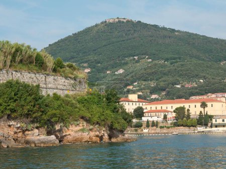 Photo for The green Coastal Italian of Spezia with stone buildings and green mountain by the water and blue sky - Royalty Free Image