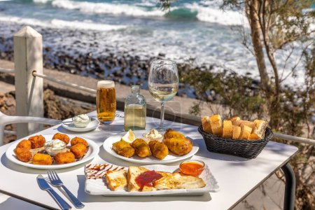 Téléchargez les photos : Un gros plan de la restauration rapide frite et du pain perdu sur une table blanche avec un fond de mer - en image libre de droit
