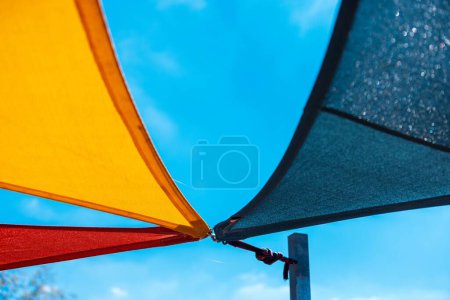 Photo for A low angle shot of colorful shade nets under the bright blue sky on a sunny day - Royalty Free Image