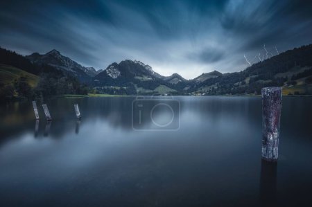 Téléchargez les photos : Un paysage de montagnes et de sapins près du lac sur un ciel nuageux - en image libre de droit