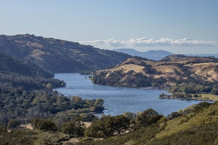 Téléchargez les photos : Une rivière qui coule à travers les montagnes avec des arbres dans le parc régional de Del Valle, Californie Central Valley - en image libre de droit