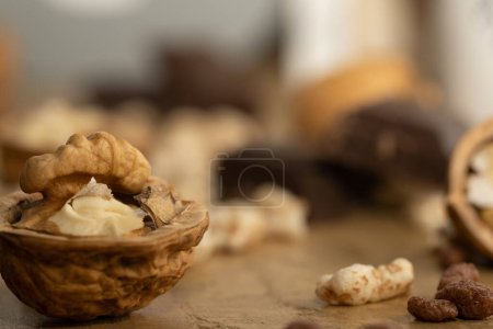 Foto de Un enfoque selectivo de nueces y barras de chocolate en una mesa de madera - Imagen libre de derechos
