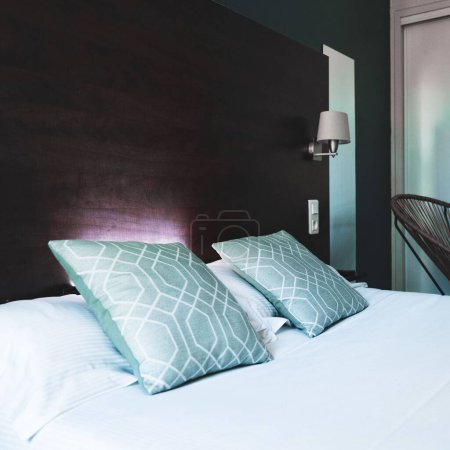 Foto de Los detalles de una cama doble con almohadas en una habitación de hotel en Aveyron, Francia. - Imagen libre de derechos