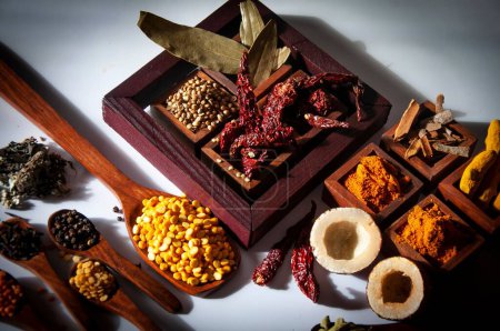 Foto de Una vista superior de una mezcla sabrosa y picante de especias indias servidas en cajas de madera y cucharas - Imagen libre de derechos