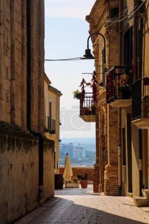 Téléchargez les photos : Vue verticale d'un balcon d'appartements sur une étroite rue pavée près de la côte en Italie - en image libre de droit