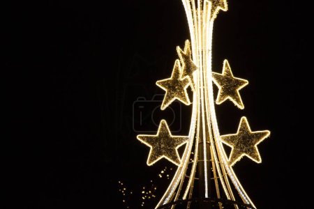 Photo for A low-key shot of the Christmas light decorations on a dark sky background in the street - Royalty Free Image