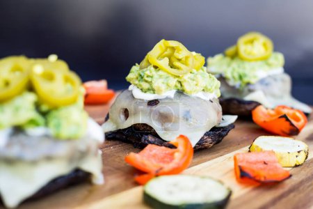 Téléchargez les photos : Un gros plan de burgers avec des jalapenos marinés et des légumes grillés sur une table en bois - en image libre de droit