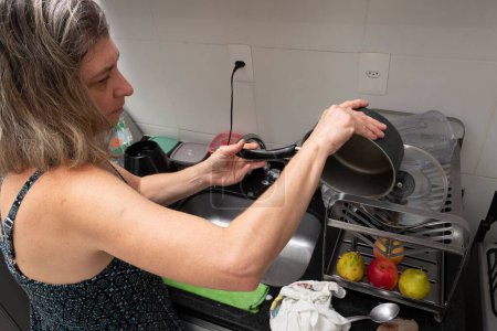 Téléchargez les photos : Un lave-vaisselle et des ustensiles féminins dans la cuisine - en image libre de droit