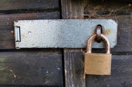 Téléchargez les photos : Plan rapproché d'un cadenas métallique sur la vieille porte en bois - en image libre de droit