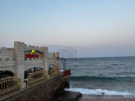 Téléchargez les photos : Un fort au bord de la mer sur un crépuscule sombre - en image libre de droit