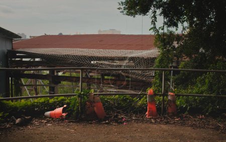 Téléchargez les photos : Les vieux cônes orange cassés abandonnés dans une cour - en image libre de droit