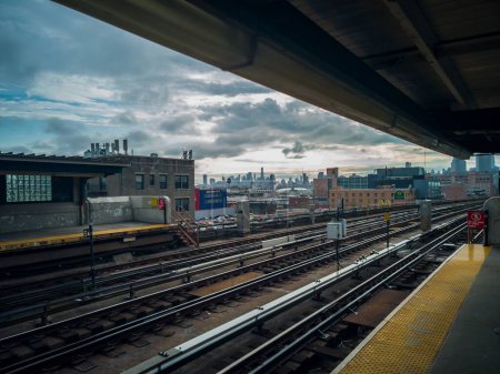 Foto de Una estación de tren vacía y las arquitecturas de Nueva York en el fondo con cielo nublado - Imagen libre de derechos