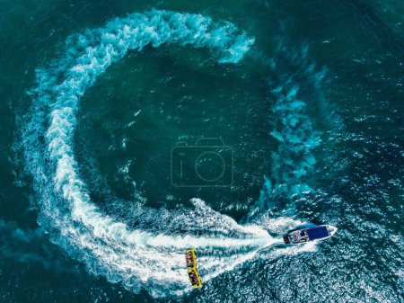 A top view of a boat making a round waves on a sea by the coast of Ashdod