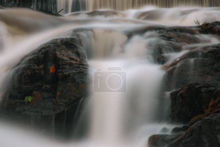 Téléchargez les photos : Un long plan d'exposition d'une cascade qui descend dans les gros rochers pendant la journée - en image libre de droit