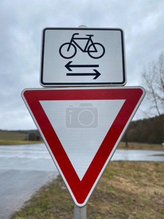 Téléchargez les photos : Un plan vertical du Rendement et des panneaux de signalisation cyclables vus sur le bord de la route - en image libre de droit