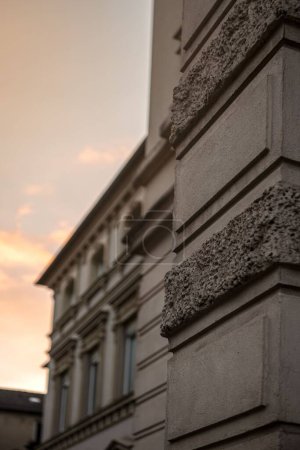 Foto de Un primer plano vertical de la pared exterior del edificio al atardecer con un cielo nublado en el fondo - Imagen libre de derechos