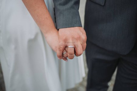 Photo for A closeup shot of a married couple holding hands, showing their wedding rings - Royalty Free Image