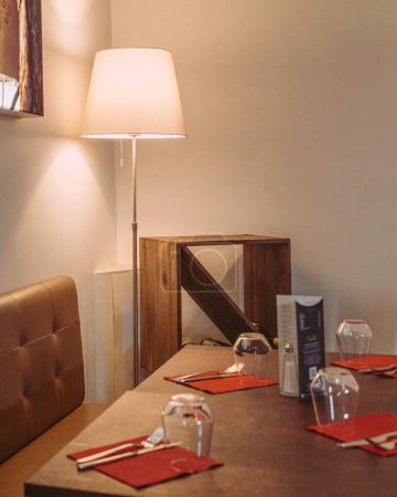 Foto de Una toma vertical de una lámpara junto a la mesa del restaurante a medio colocar - Imagen libre de derechos