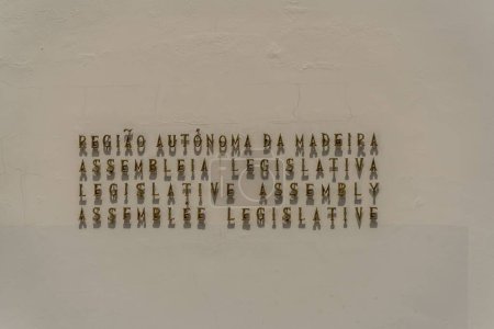 Téléchargez les photos : Plan rapproché de l'inscription métallique sur le mur de l'Assemblée législative de Madère - en image libre de droit