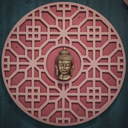 Photo for A buddha head in a circular pattern on a wall - Royalty Free Image