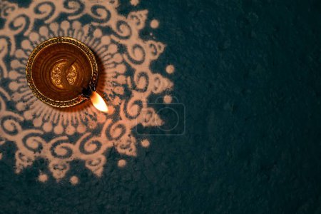 Téléchargez les photos : Un fond sarcelle avec une lampe à huile d'argile dorée pour le Festival des Lumières de Diwali - en image libre de droit
