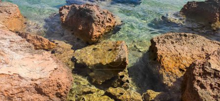 Foto de Una vista panorámica de las rocas en el agua cristalina en Paleo Kalamaki, Grecia - Imagen libre de derechos