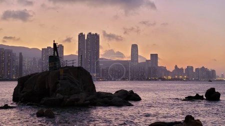 Téléchargez les photos : Le phare de Lei Yue Mun Coast entouré de gratte-ciel à Hong Kong - en image libre de droit